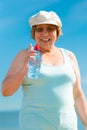 Old woman drinking mineral water in plastic bottle outdoor Royalty Free Stock Photo