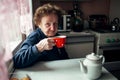 An old woman drinking tea in the kitchen at her home. Royalty Free Stock Photo