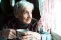 An old woman drinking tea sitting in the kitchen Royalty Free Stock Photo