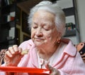 Old woman eating a slice of bread