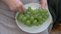 Old woman eats grapes. Top view. Close uo shot Royalty Free Stock Photo