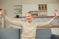 An elderly woman experiences the joy of being at home with her arms wide open. Happy pensioner concept Royalty Free Stock Photo