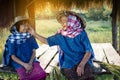 Old woman farmer and granddaughter sitting at cabin after harvesting in rice field Royalty Free Stock Photo