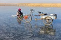 An old woman is fishing through an ice hole