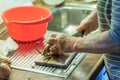 Old woman granny cutting onion in kitchen with knife and wooden board next to sink and red plastic bowl, Germany Royalty Free Stock Photo