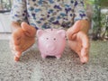 Old woman hand prevent Pink piggy bank standing on marble floor. Saving money for future plan and retirement fund concept Royalty Free Stock Photo