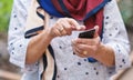 Old woman hands using smartphone texting sending messages on mobile phone outdoors Royalty Free Stock Photo