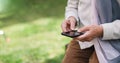 Old woman hands using smartphone texting sending messages on mobile phone outdoors Royalty Free Stock Photo