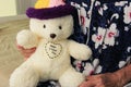 Old woman holding bear doll