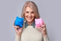 Old woman holding two piggy banks Royalty Free Stock Photo