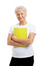 An old woman holding a workbook.