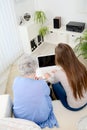 Old woman at home with cheerful young girl spending time together with laptop computer Royalty Free Stock Photo