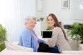Old woman at home with cheerful young girl spending time together with laptop computer Royalty Free Stock Photo