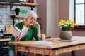 Old woman leaning on hand having look at vedic drawings Royalty Free Stock Photo