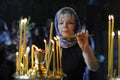 Old woman lighting candles in a church