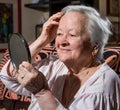 Old woman looking into a mirror Royalty Free Stock Photo