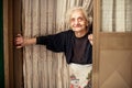 Old woman looking out of the door Royalty Free Stock Photo