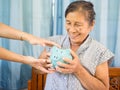 Old woman looking scared trying to protect her blue piggy bank from Financial fraud, Saving money for future plan and retirement Royalty Free Stock Photo