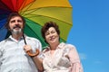 Old woman and man holding multicolored umbrella Royalty Free Stock Photo