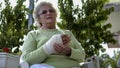 Old woman massage her injured broken hand sitting Royalty Free Stock Photo