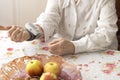 The old woman measures arterial pressure while sitting in the living room at the table. Royalty Free Stock Photo