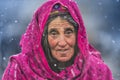 Old woman in the middle of snow waiting animals to return from pasture. Royalty Free Stock Photo