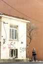 An Old Woman Is Passing Near Of A Home And Tree