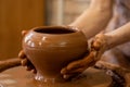 Old woman potter working on Potter wheel making a clay pot. Master forming the clay with her hands creating pot in a Royalty Free Stock Photo