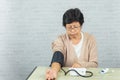 Old woman with pressure gauge checking blood pressure level on the table Royalty Free Stock Photo