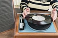 Old woman puts a vinyl record Royalty Free Stock Photo