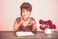 Old woman reading book with glasses at flowers. Royalty Free Stock Photo