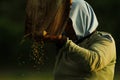 An old woman in a rice field separating grain in a traditional way