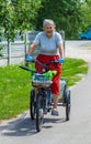 An old woman rides a bicycle. Selection focus.