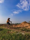 An old woman riding a bicycle on a rice field road. Portrait of an Indonesian farmer .