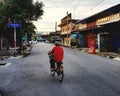 Old woman riding bicycle on road Royalty Free Stock Photo