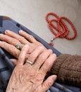 Old woman with ring on her finger worships her hand with rosary