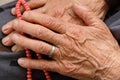 Old woman with ring on her finger worships her hand with rosary