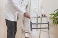 A geriatric doctor teaches to walk an old woman using a rehabilitation walker. Royalty Free Stock Photo