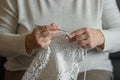 Old woman& x27;s hands knitting with crochet hook. Grandma crocheting with white thread a lace tablecloth. Handicraft