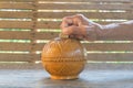 Old woman\'s hands putting Thai baht coins in a round wooden box, money saving idea Royalty Free Stock Photo