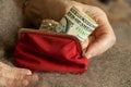 old woman& x27;s hands take out a dollar bill from a soft red wallet, money in a wallet Royalty Free Stock Photo