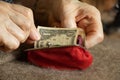 old woman& x27;s hands take out a dollar bill from a soft red wallet, money in a wallet Royalty Free Stock Photo