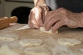 The old woman`s overworked hands are making pies out of dough. Hand-made homework with baked goods