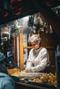 Old woman selling Christmas food at a Christmas market in Basel, Switzerland.