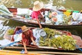 Old woman selling fruits and vegetables in a traditional floating market Royalty Free Stock Photo