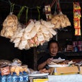 Old woman selling raw noodles in a small Indonesian street shop