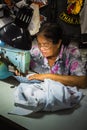 Old woman sews on the sewing machine in the street