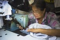 Old woman sews on the sewing machine in the street