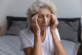 Elderly woman closed eyes touch temples suffers from migraine Royalty Free Stock Photo