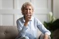 Mature woman sitting on couch say voice message using smartphone Royalty Free Stock Photo